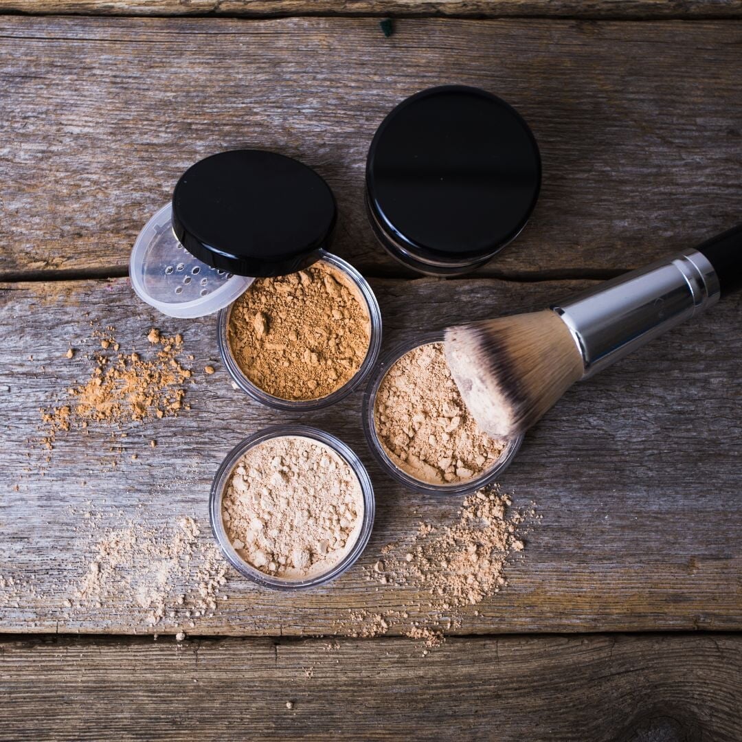various mineral makeup containers with brushes on top