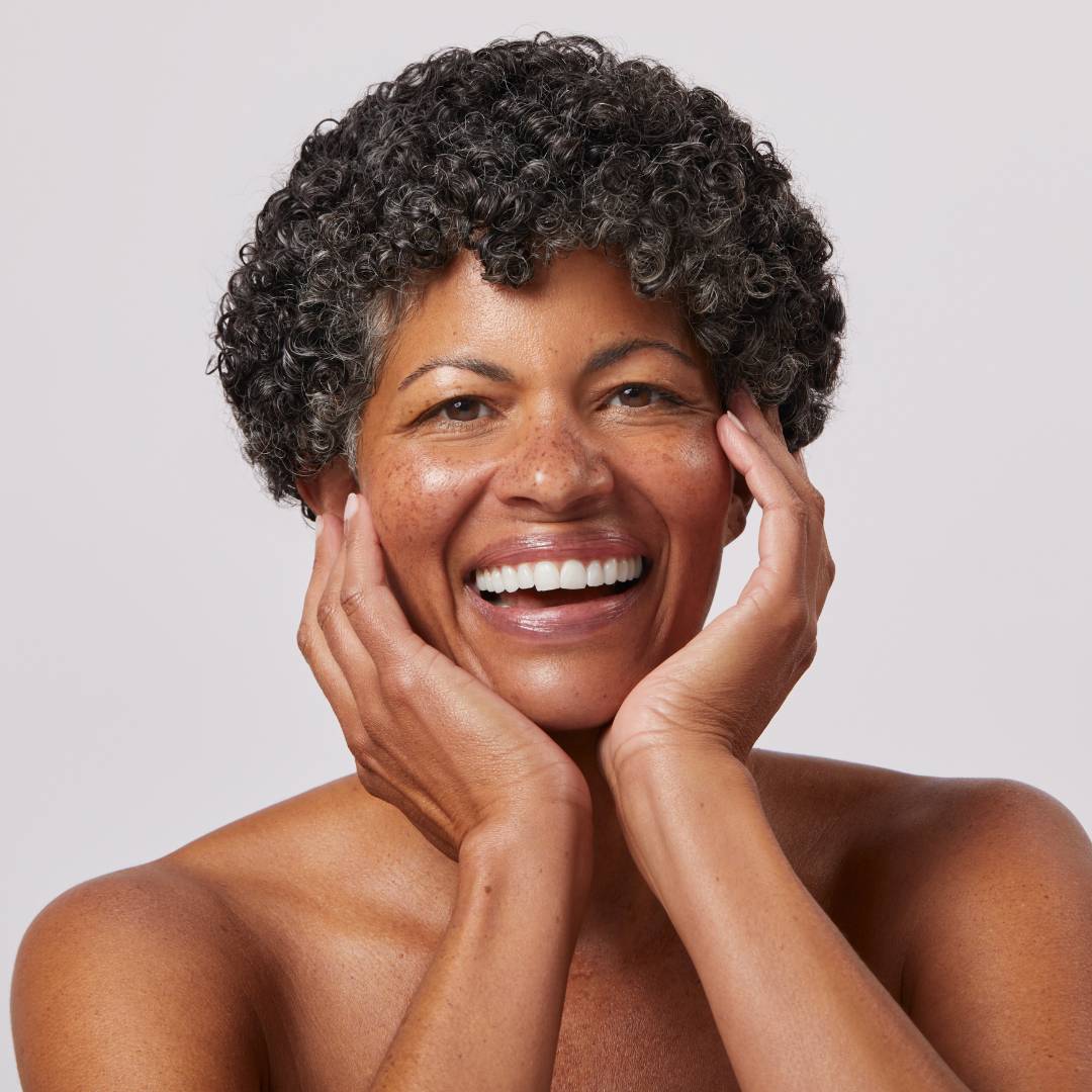model in her 40s on a gray background