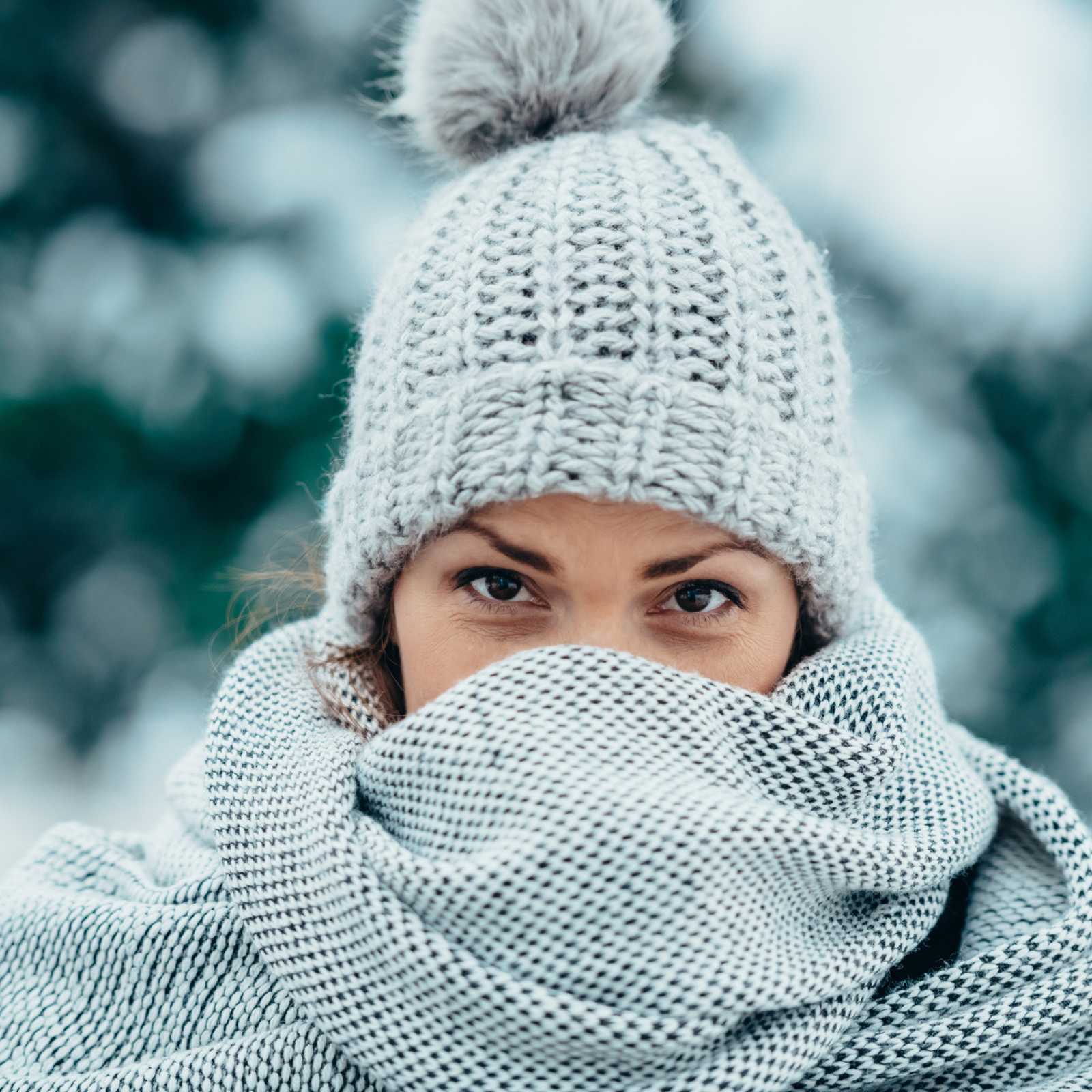 woman in hat and scarf with snow in the background