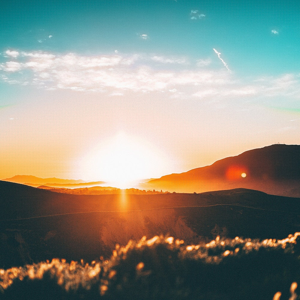 sun setting behind mountains