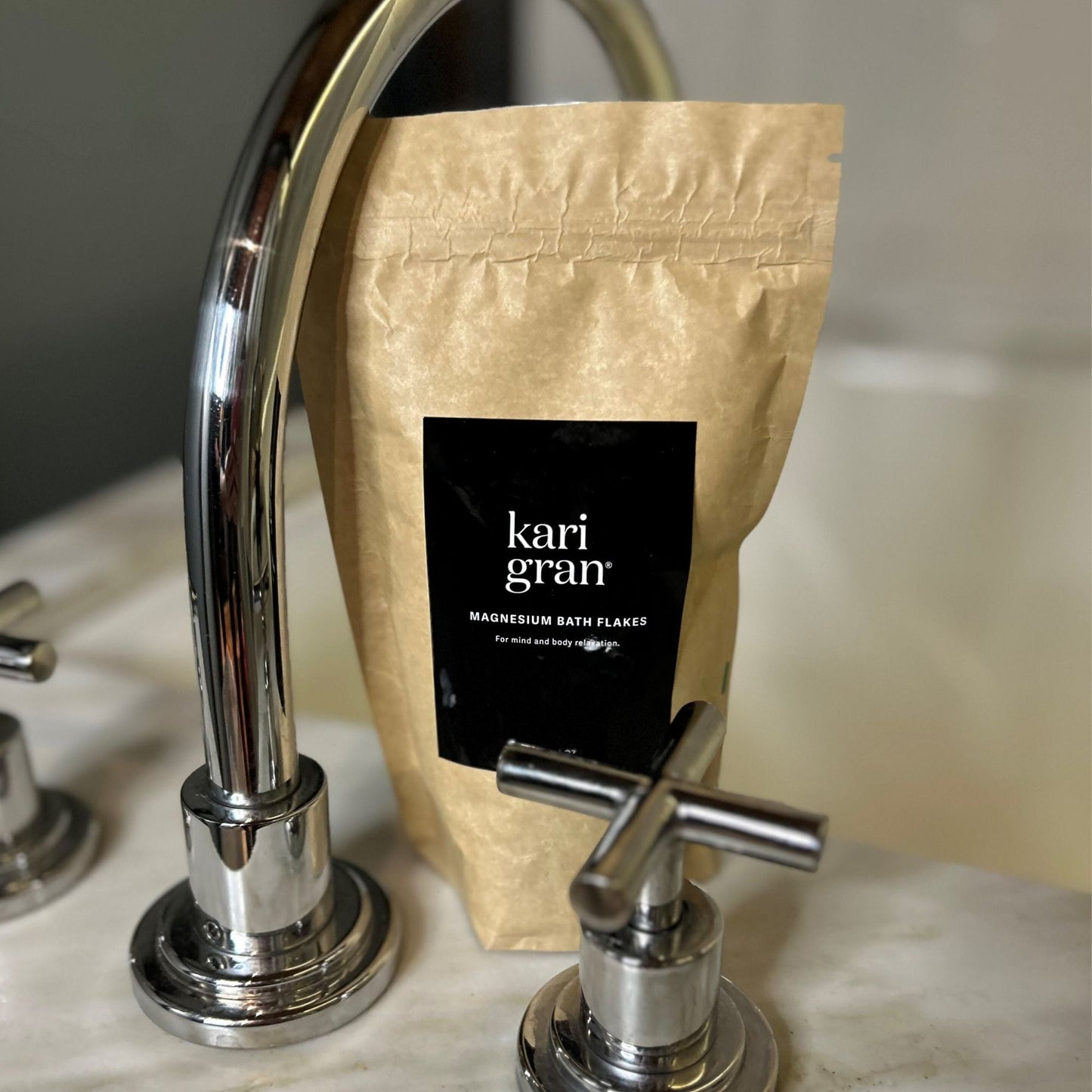 Image of magnesium bath flakes in packaging on edge of bathtub