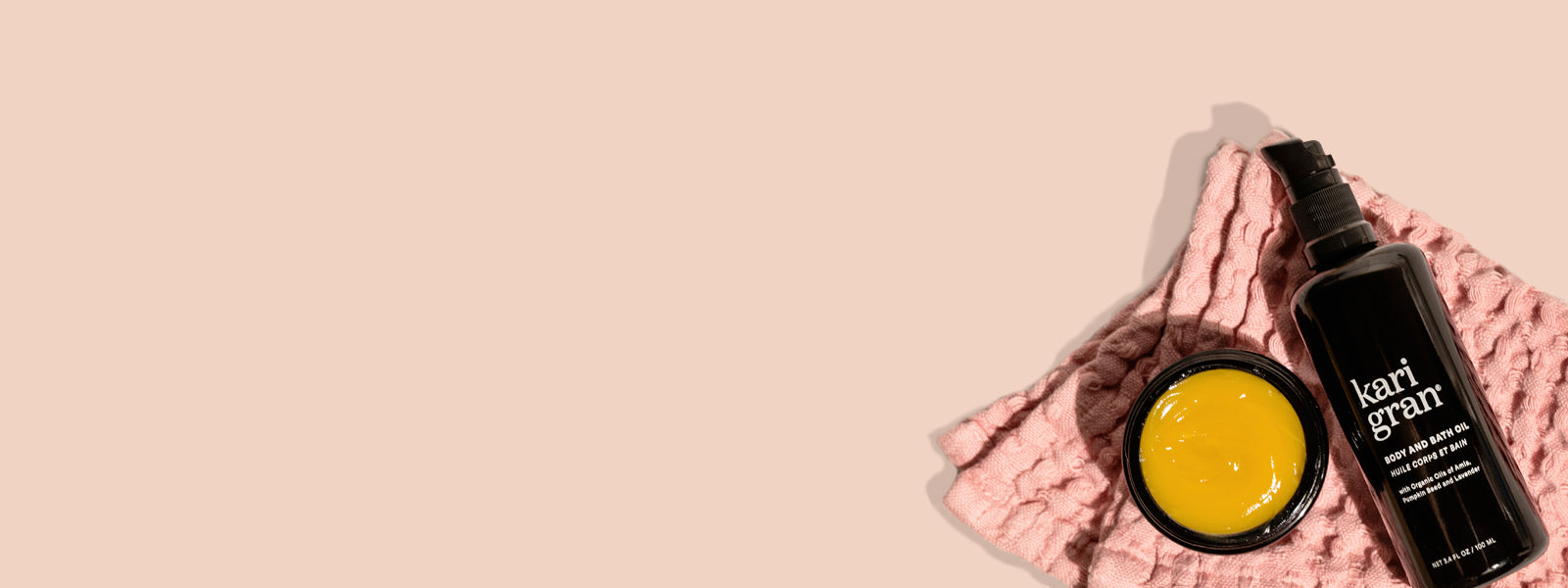 Kari Gran Body and Bath Oil with Essential Serum Balm on pink washcloth