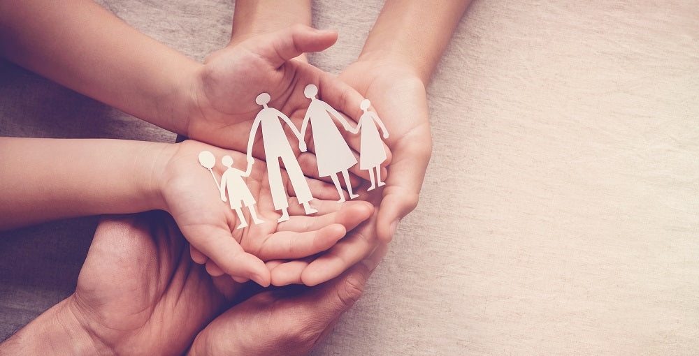 Kari Gran hands holding paper cutout of family