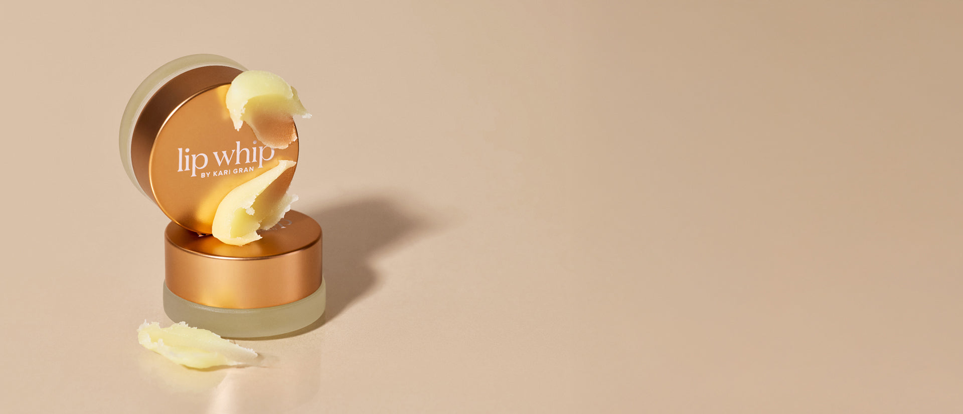 Lip balm container with 'lip whip' branding on a beige background