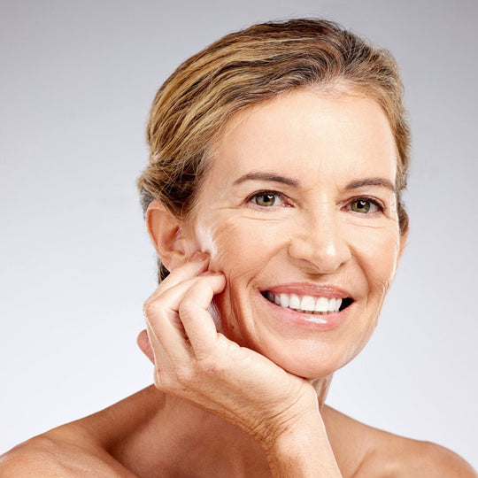 woman smiling with hand on her chin.