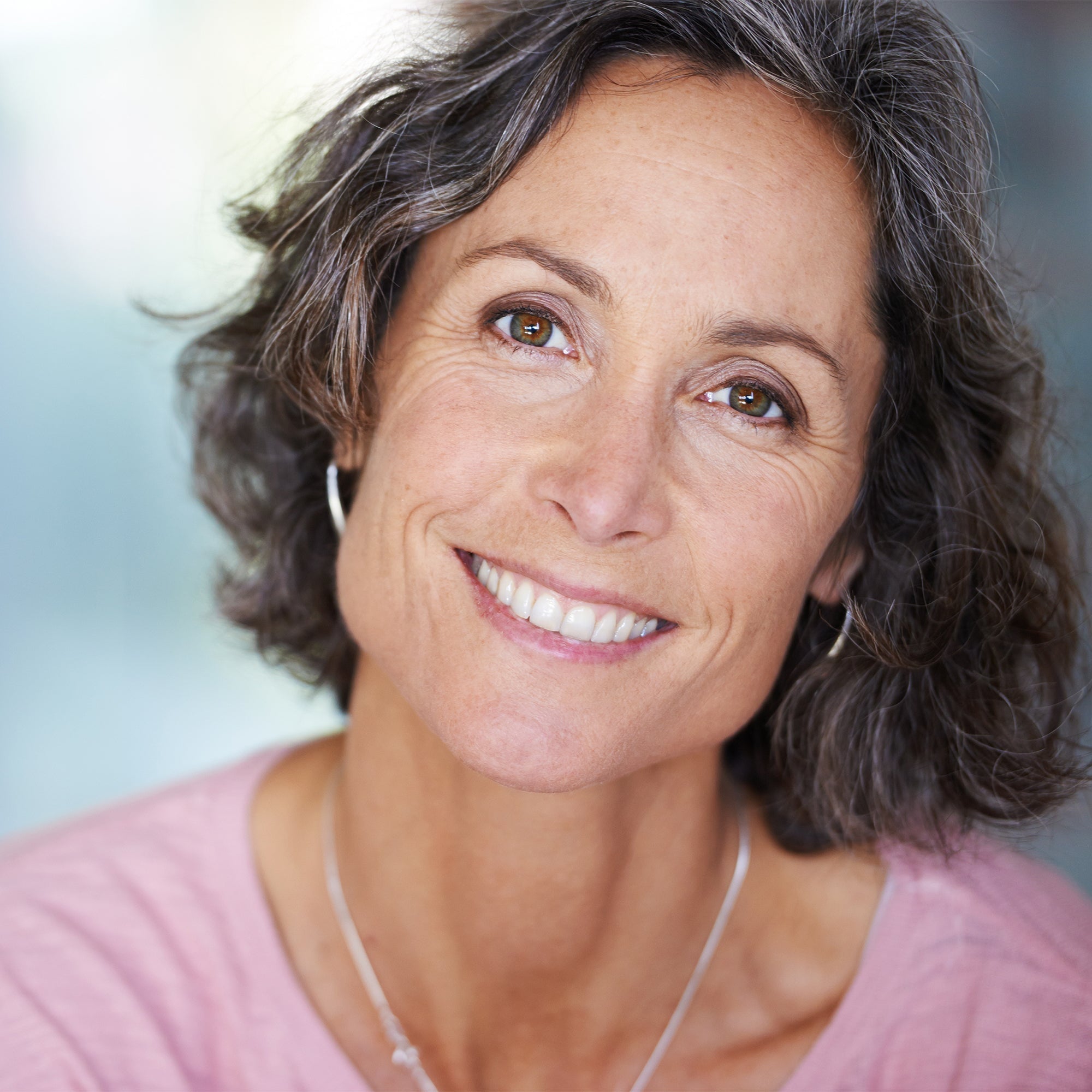 photo of a woman in her 40s smiling, dry skin and menopause
