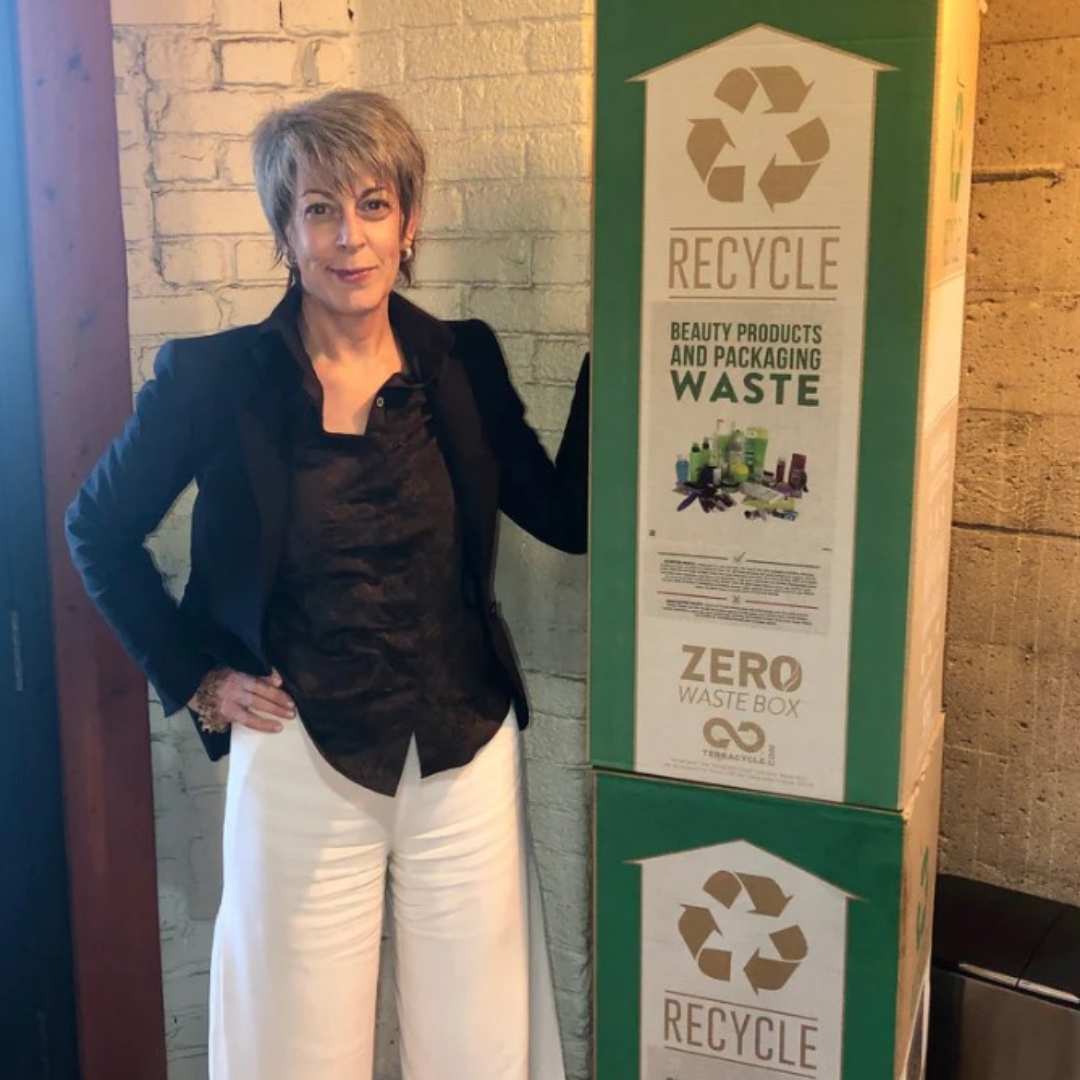 Lisa standing next to recycling boxes