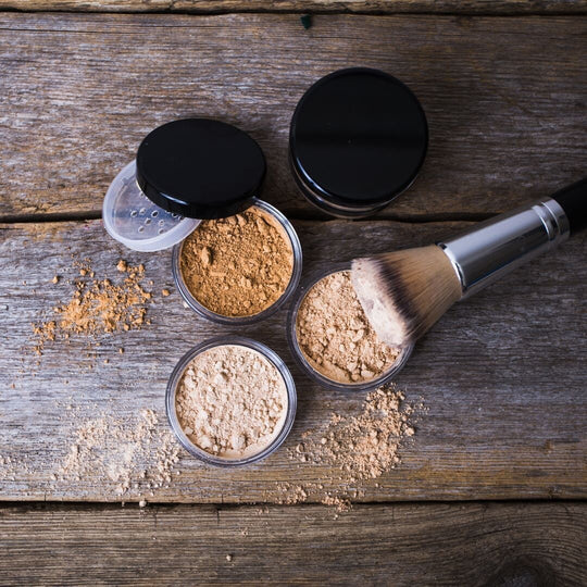 various mineral makeup containers with brushes on top