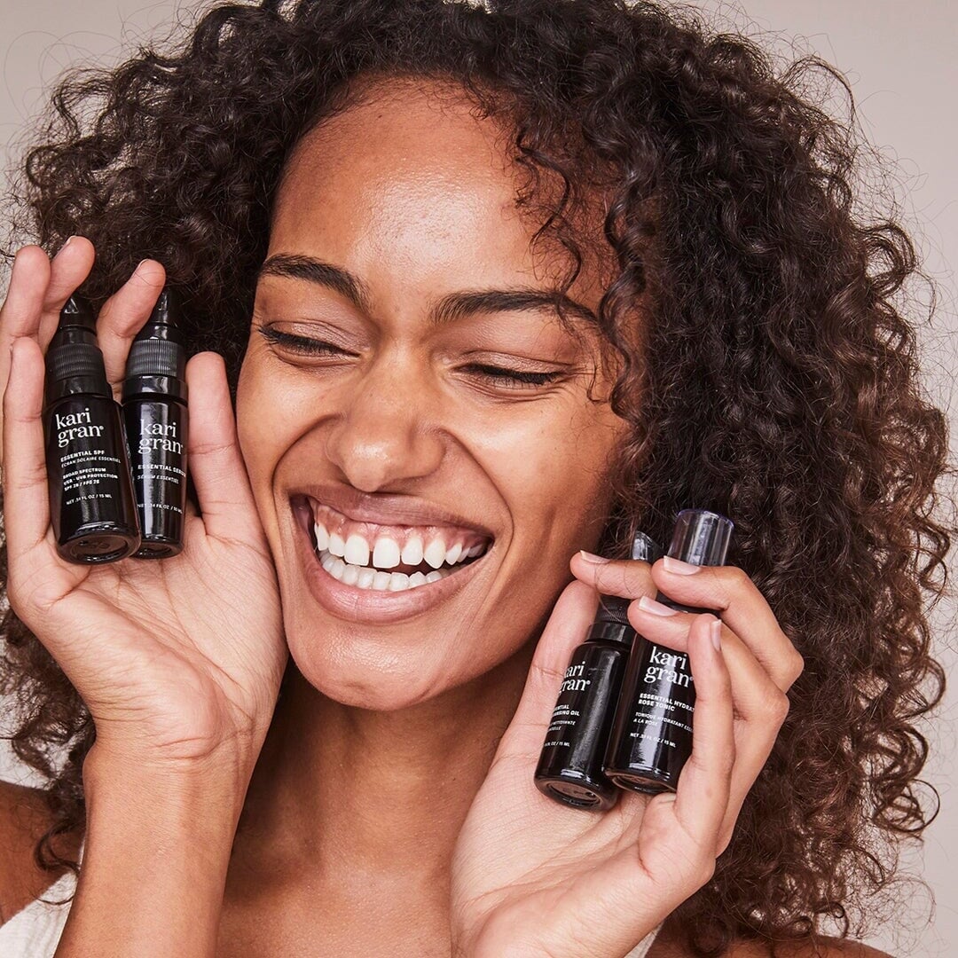 woman holding kari gran mini skincare bottles
