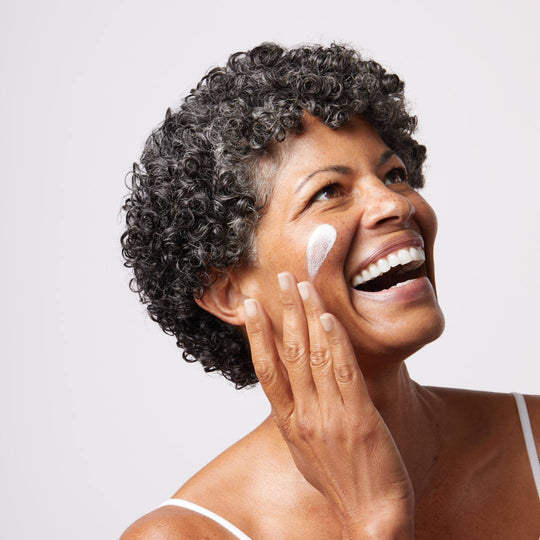 woman in her 40s with a swipe of oil-based spf on her face