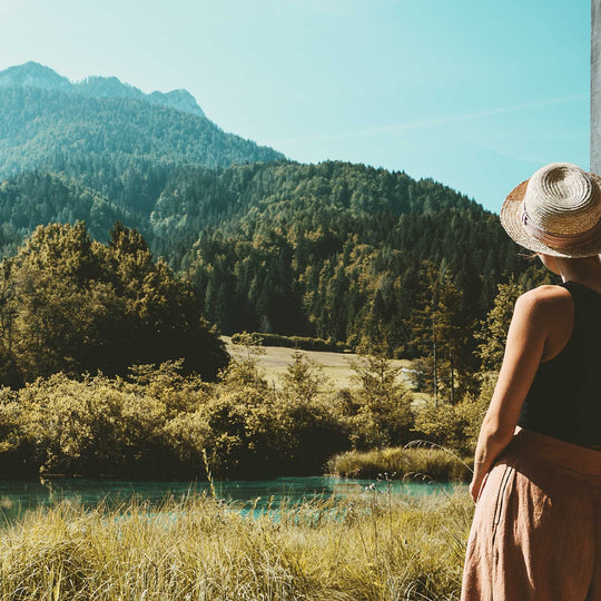woman on porch looking at field and mountains