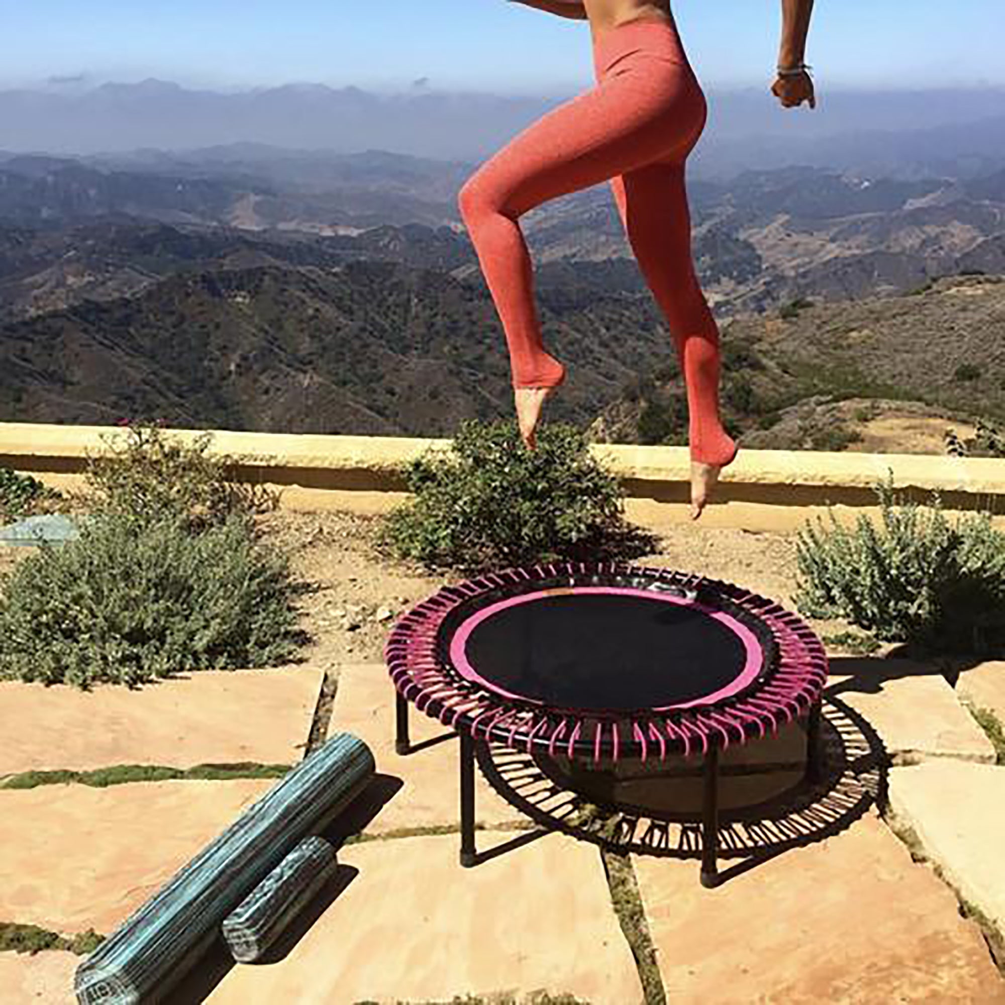 woman jumping on trampoline in the desert