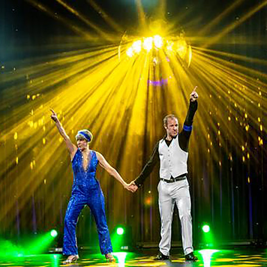 Lisa Strain dancing with partner in blue sequin jumpsuit