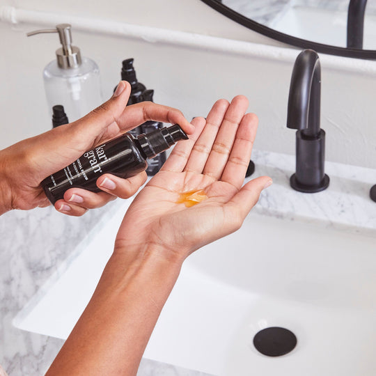 woman pumping Kari Gran Essential Serum in palm