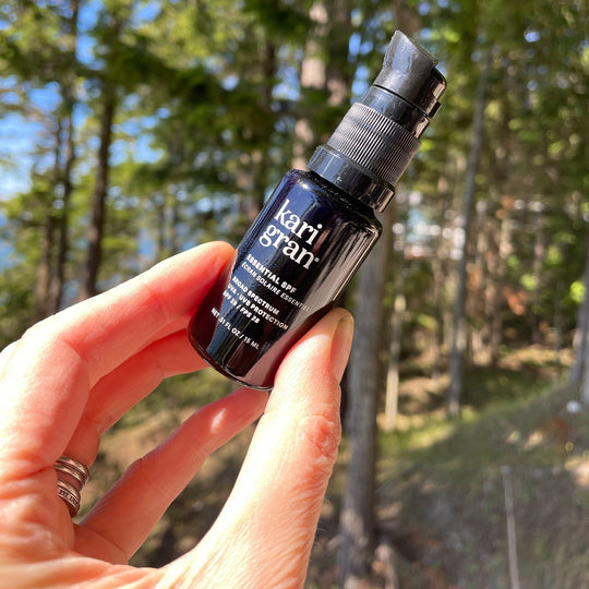 Woman holding a mini size of the KG essential spf in a forest