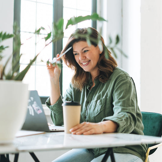 Kari Gran wearing sunscreen indoors- woman sitting near window working on her laptop