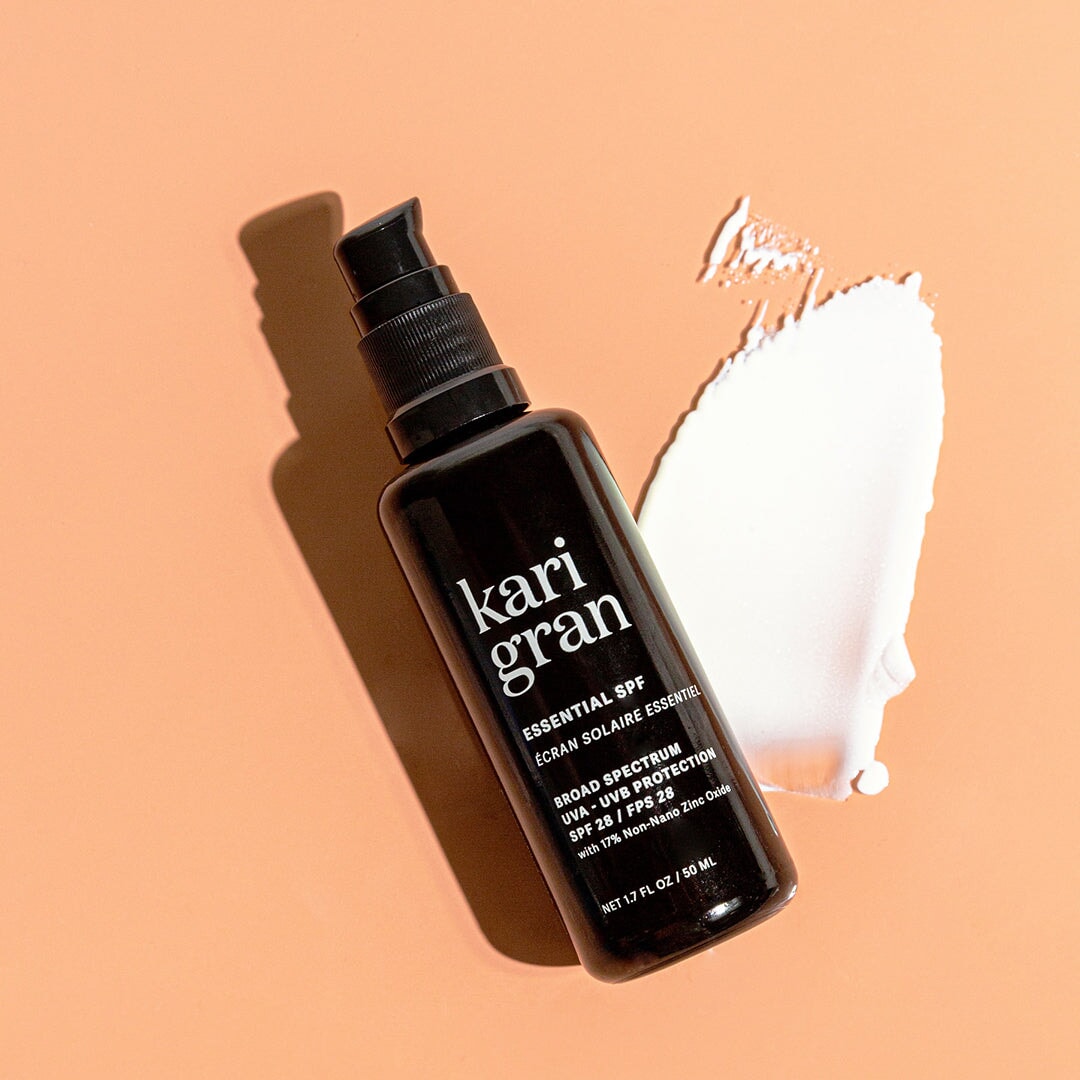 KG essential SPF with swatch right next to the bottle with a tan background