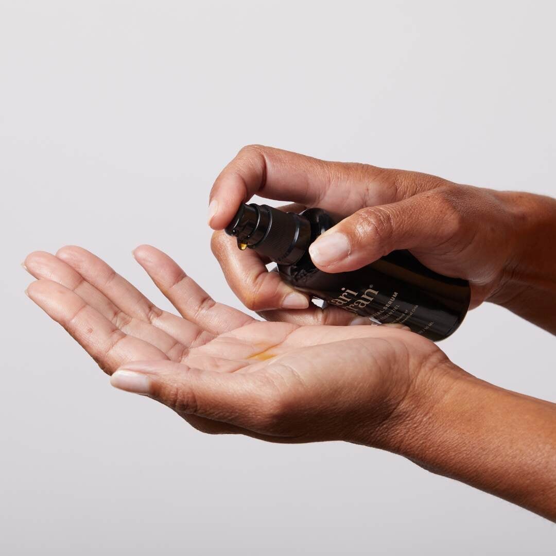 woman's hands holding an oil-based serum