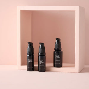 kg mini bottles of the cleansing oil, essential peptide serum and vitamin c serum on pink background