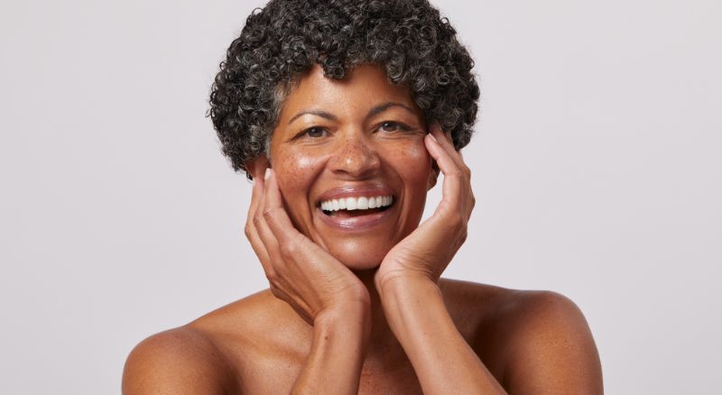 Woman smiling with hands on face