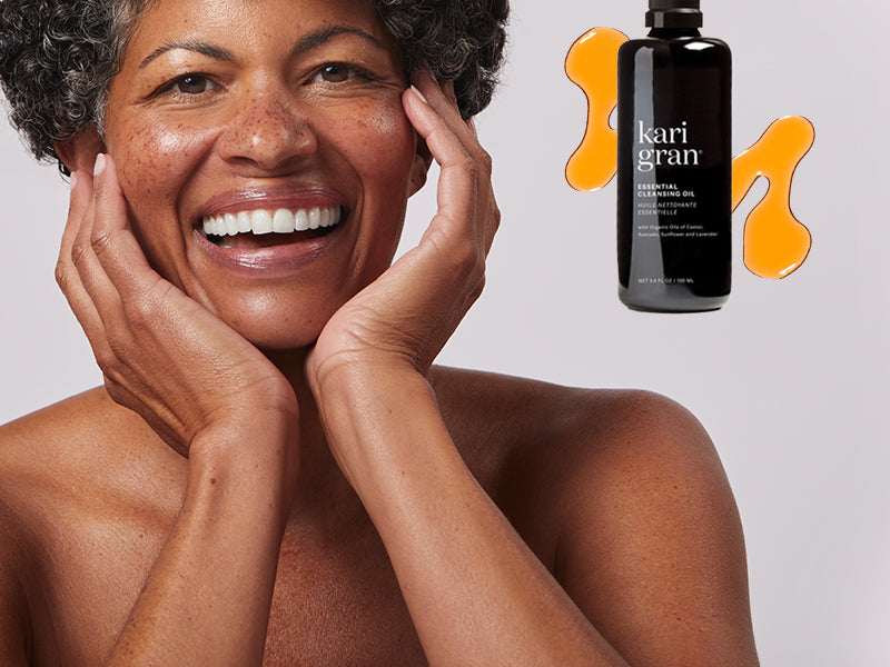 model smiling next to a bottle of the cleansing oil