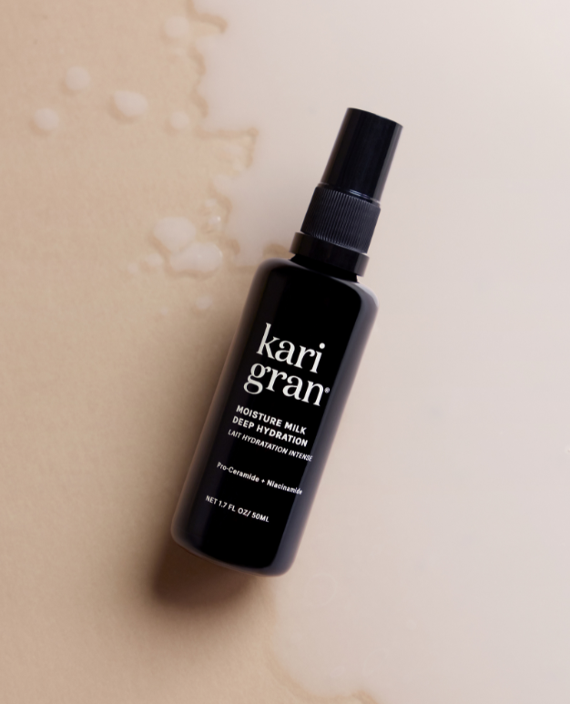 Black spray bottle labeled 'kari gran' on a beige background