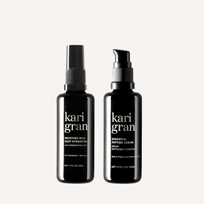 Two black bottles of kari gran skincare products on a light gray background