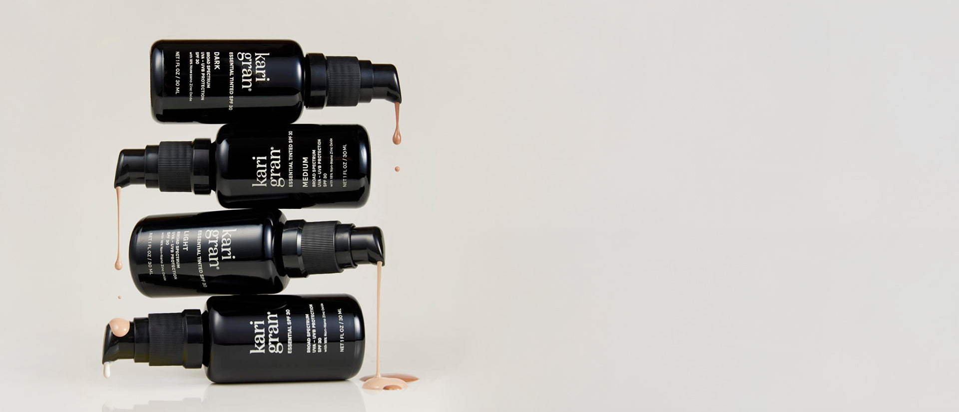 Set of black skincare bottles with visible branding on a light gray background