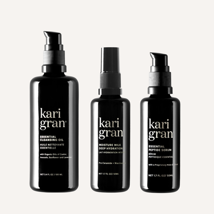 Three black bottles of kari gran skincare products on a white background