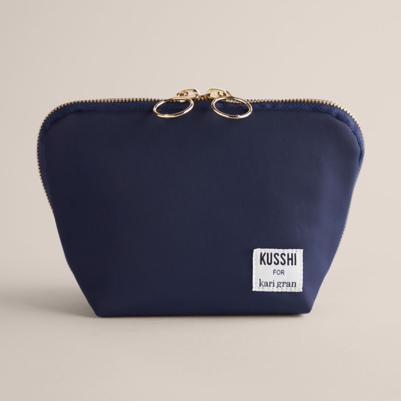 kusshi bag for kari gran. Navy bag on a beige background